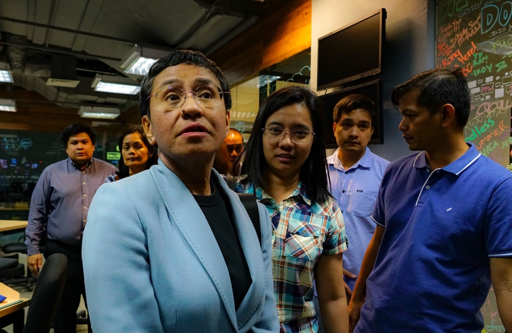 Philippine journalist Maria Ressa (front L) leaves her office after she was arrested in Manila on February 13, 2019. (AFP / MARIA TAN)