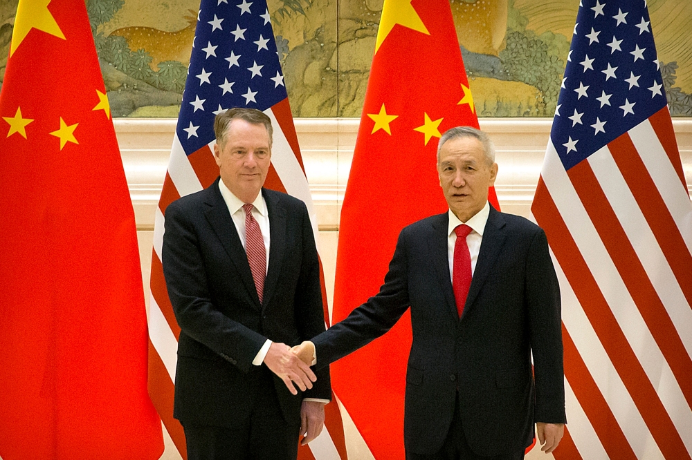 US Trade Representative Robert Lighthizer (L) and Chinese Vice Premier and lead trade negotiator Liu He shake hands as they pose for a photo before the opening session of trade negotiations at the Diaoyutai State Guesthouse in Beijing on February 14, 2019