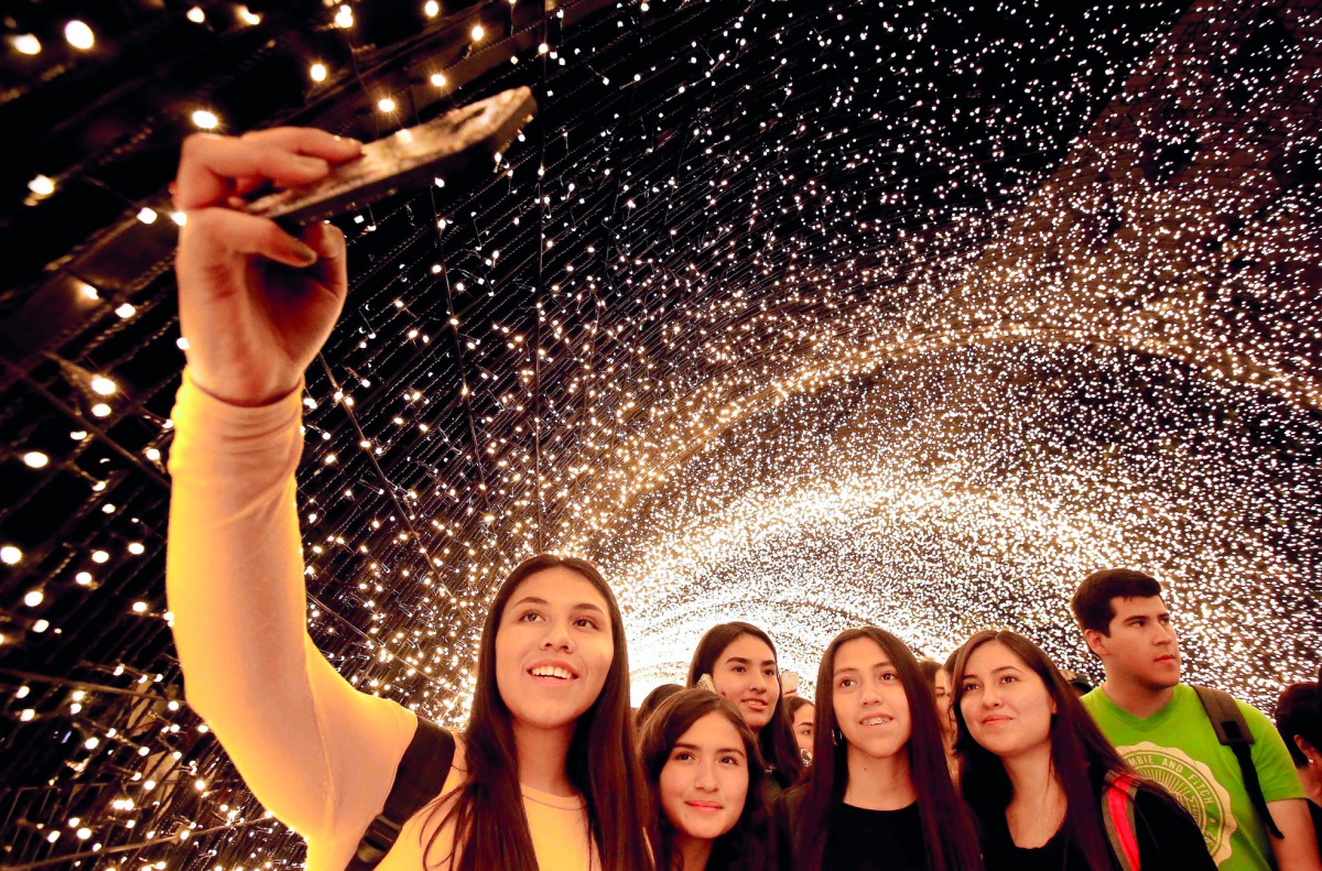 People enjoy a light show during the festivities for the 477th anniversary of the foundation of Guadalajara, Mexico, on February 14, 2019. The city begins the anniversary celebrations on February 14 with the largest robotic light festival in Latin America