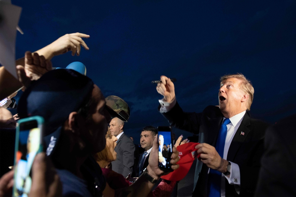 US President Donald Trump is greeted by supporters upon his arrival in West Palm Beach, Florida, on February 15, 2019. / AFP / Jim WATSON
