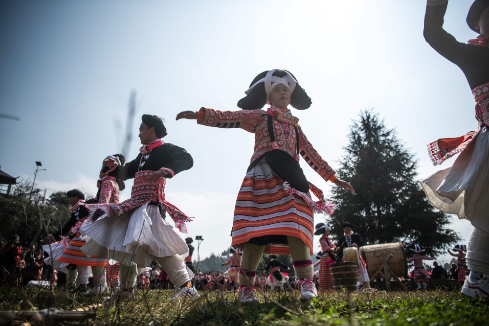 This photo taken on February 14, 2019 shows girls from the Long Horn Miao, a branch of the Miao ethnic minority group, taking part in the annual flower festival or 'Tiaohuajie' in the village of Longjia in China's Guizhou province.  / AFP / FRED DUFOUR 