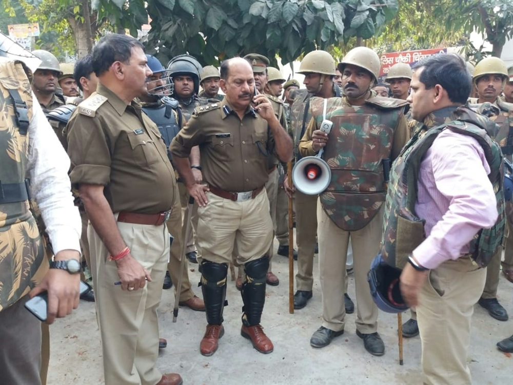 (FILES) In this file photo taken on December 3, 2018, policemen gather outside a police station following reports of mob violence at Chingravati village in Bulandhahr, India's northern Uttar Pradesh state. AFP 
