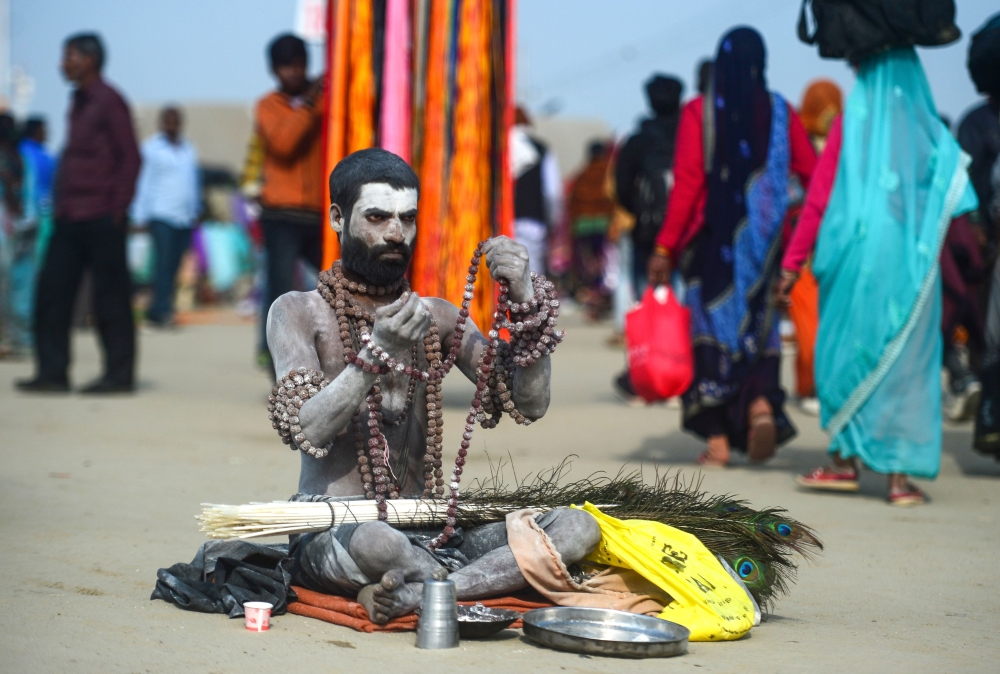 An Indian sadhu sits on the banks of Sangam -- the confluence of the Ganges, Yamuna and mythical Saraswati rivers -- on the auspicious bathing day of 'Maghi Purnima' during the Kumbh Mela festival in Allahabad on February 19, 2019.  AFP / Sanjay Kanojia 
