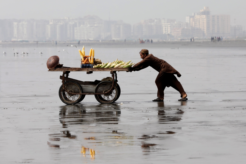 A man pushes a cart as he sells cooked corn on Clifton beach in Karachi, Pakistan February 20, 2019. Reuters/Akhtar Soomro