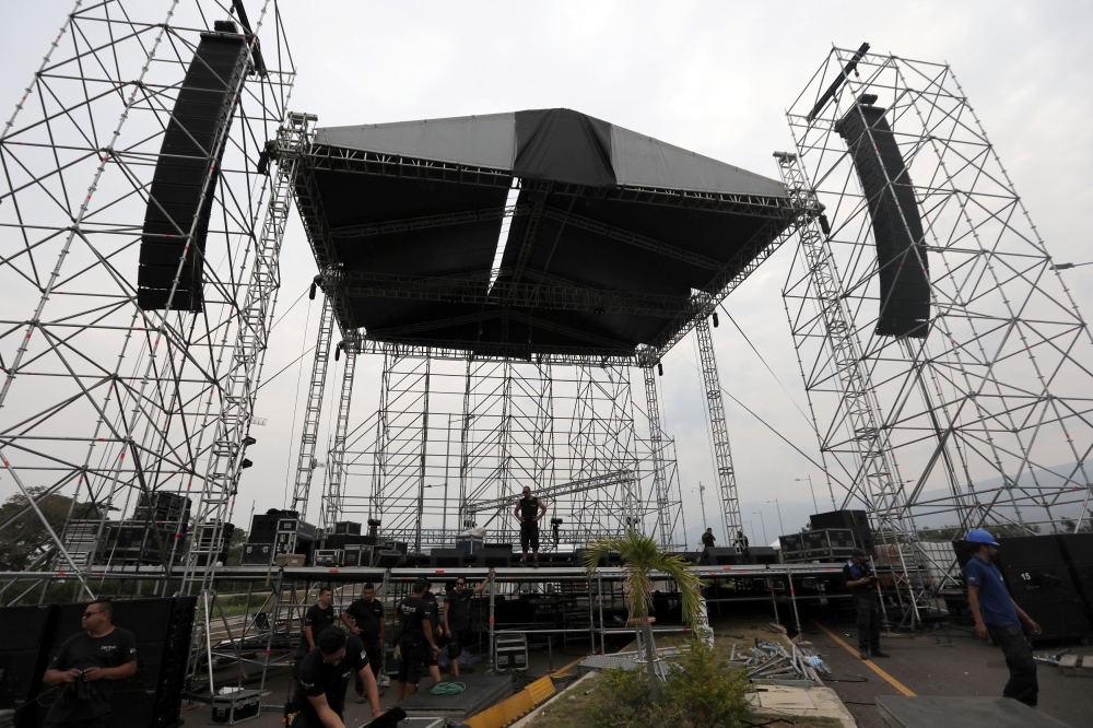 Workers set up a platform for the upcoming concert 