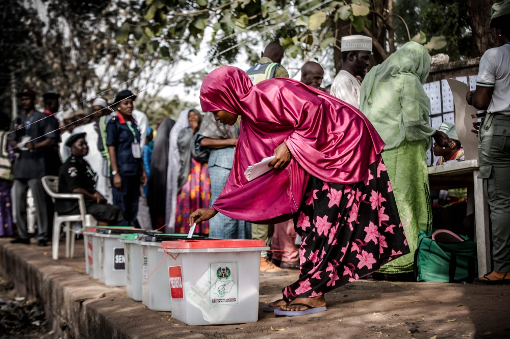 A Nigerian woman casts her vote for a candidate in the presidential election at Agiya polling station a few hours before polls opened in Yola, Adamawa State, Nigeria on February 23, 2019. / AFP / Luis TATO 