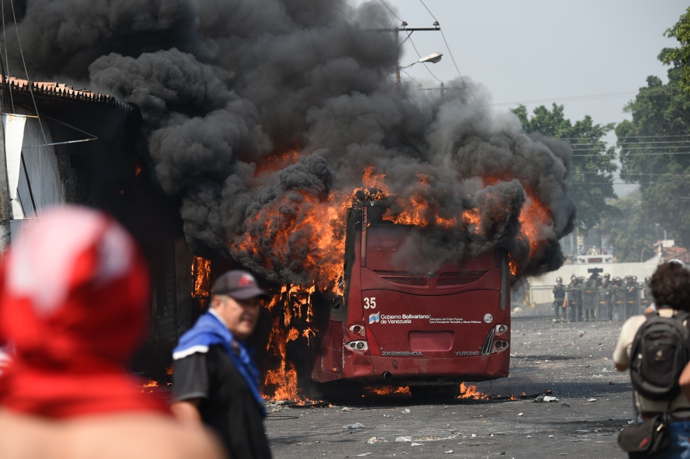 A bus burns down during a protest in the border city of Urena, Tachira, after President Nicolas Maduro's government ordered a temporary close-down of the border with Colombia on February 23, 2019.  AFP / JUAN BARRETO
