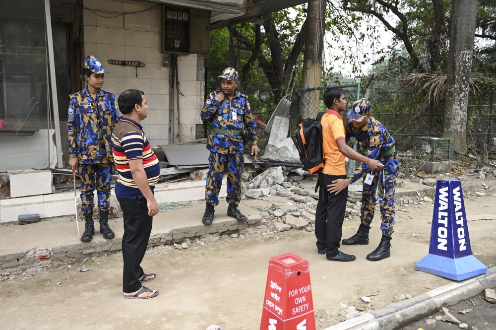 Bangladeshi security personnel search people at an entrance to the Hazrat Shahjalal International Airport in Dhaka on February 25, 2019, as Bangladesh's authorities boost up security the day after an attempted plane hijack.  AFP / Munir Uz Zaman 