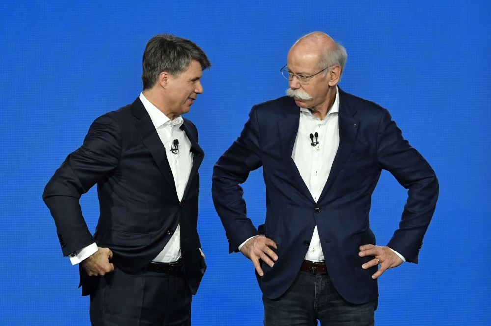 The CEO of German auto giant Daimler AG Dieter Zetsche (R) and CEO of German carmaker BMW Harald Krueger gesture after they presented the merger of their car sharing activities on February 22, 2019 in Berlin. AFP / John MACDOUGALL