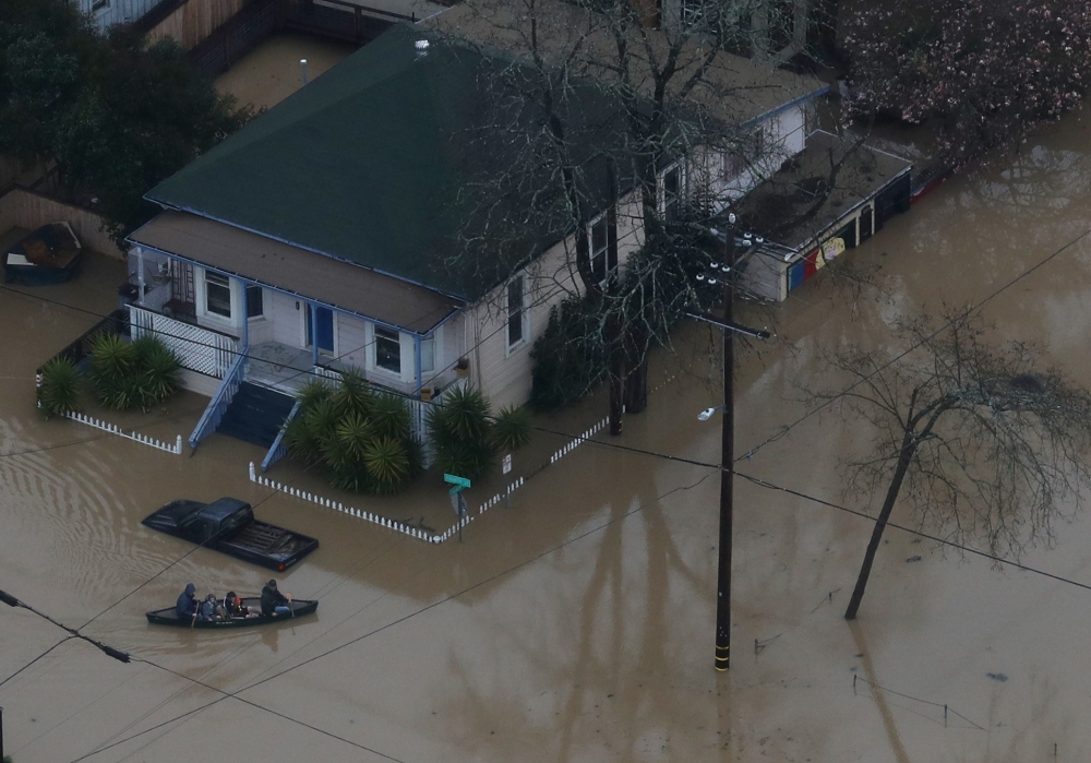 GUERNEVILLE, CALIFORNIA - FEBRUARY 27: People paddle a boat through a flooded neighborhood on February 27, 2019 in Guerneville, California. AFP 