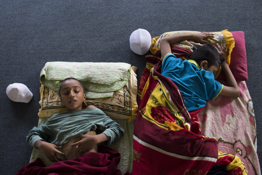 Mohammed Usman (L) and Alam Shah, two Rohingyan students take a nap during the afternoon break at religious school run by a Rohingya NGO, Majlis Ulama Rohingya in Selangor, Malaysia on February 19, 2019. (Adli Ghazali/Anadolu Agency)