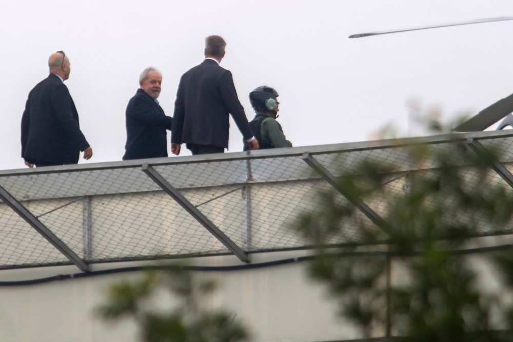 Brazilian former president Luiz Inacio Lula da Silva (2nd L) leaves the Federal Police headquarters in Curitiba, Parana state, where he is serving a 12-year prison sentence, to attend the funeral of his grandson on March 2, 2019.AFP / FRANKLIN DE FREITAS