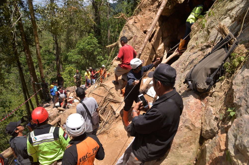 Members of an Indonesian search and rescue team work on the site after a mine collapsed in Bolaang Mongondow, North Sulawesi on February 28, 2019.  / AFP / UNGKE PEPOTOH 