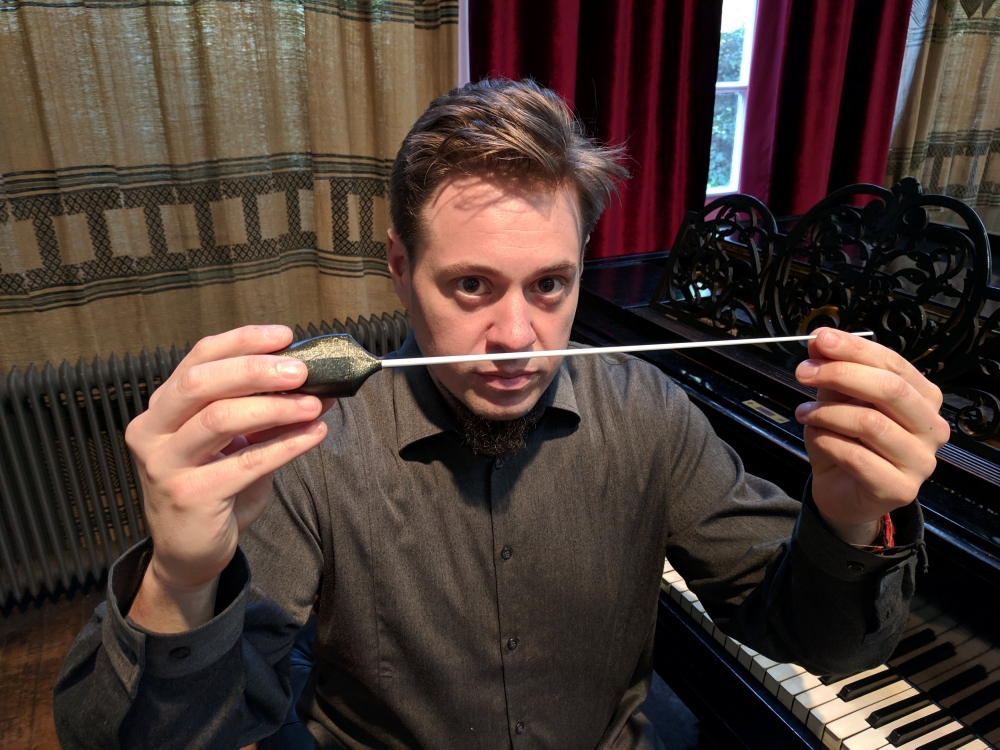 Vahakn Matossian poses for the camera holding his haptic baton which allows blind people to follow a conductor in an orchestra, in a studio in London, Britain February 21, 2019. Reuters/Stuart McDill