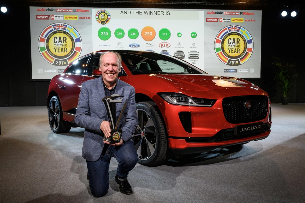 Jaguar design director Ian Callum poses next to a Jaguar I-Pace model car awarded European Car of the year 2019, ahead of the start of the Geneva International Motor Show 2019 on March 4, 2019 in Geneva. AFP / Fabrice Coffrini 