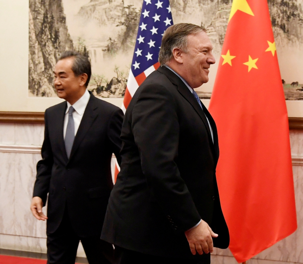 FILE PHOTO: U.S. Secretary of State Mike Pompeo is seen near Chinese State Councilor and Foreign Minister Wang Yi before a meeting at the Diaoyutai State Guesthouse in Beijing, China October 8, 2018. Daisuke Suzuki/Pool via Reuters/File Photo