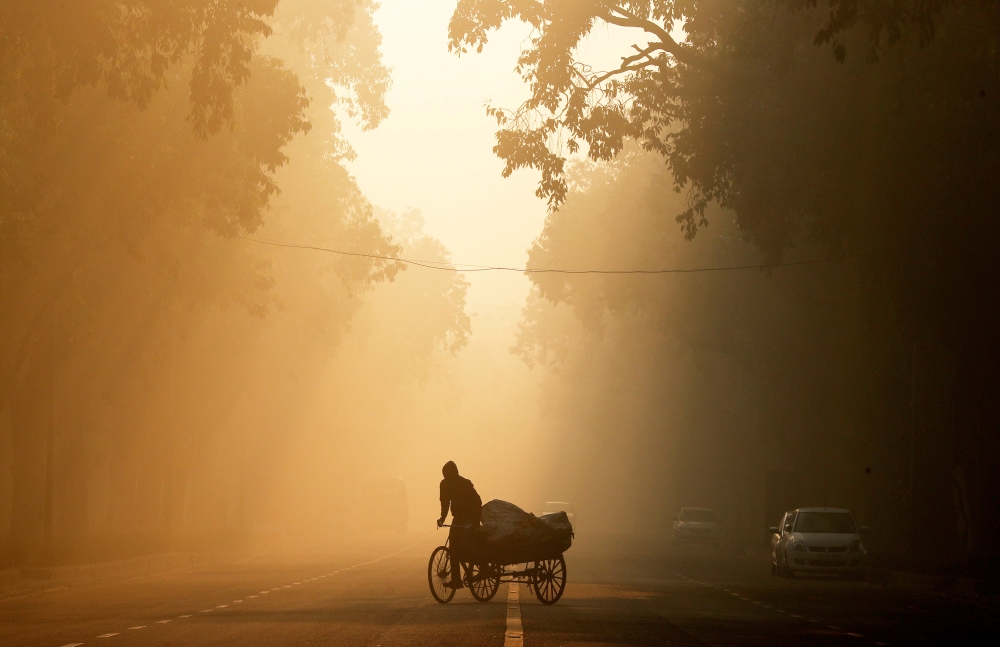 FILE PHOTO: A man rides a rickshaw on a smoggy morning in New Delhi, India, December 26, 2018. REUTERS/Adnan Abidi