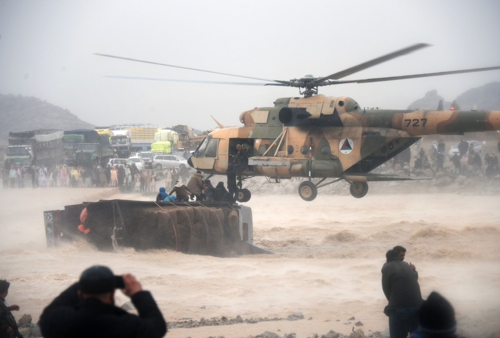 An Afghan military helicopter rescues people from atop an overturned truck in flooded area of Arghandab district in Kandahar province.  AFP / JAVED TANVEER
