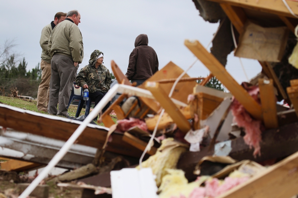 Julie Morrison (C), sits on a salvaged chair, surrounded by friends, as she looks at the wreckage of her home after two deadly back-to-back tornadoes, in Beauregard, Alabama,  March 4, 2019. Reuters/Elijah Nouvelage
