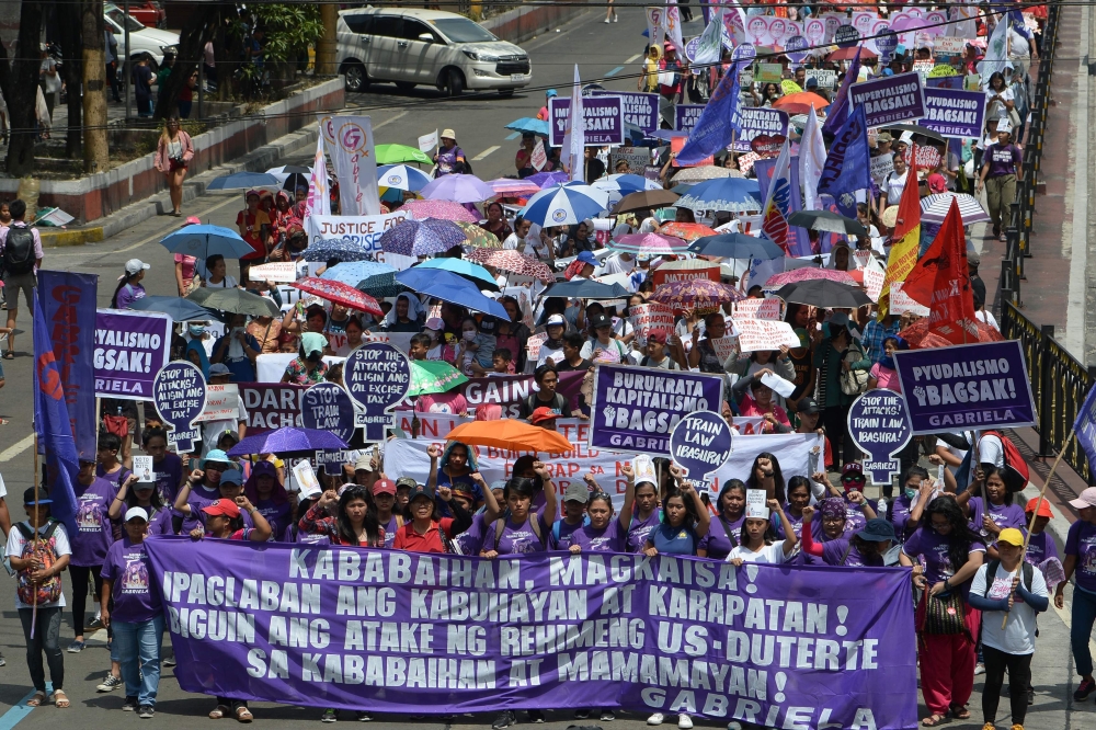 Activists from Gabriela march toward Malacanang palace to commemorate International Women's Day in Manila on March 8, 2019. AFP / Ted Aljibe
 