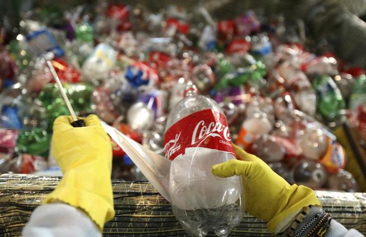 A worker removes labels from recycled plastic bottles to be used in the construction of the sailboat Plastiki at Pier 31 in San Francisco, March 13, 2009. Reuters/Robert Galbraith