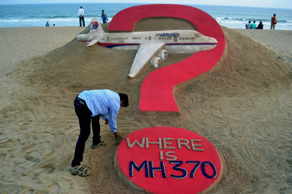 This file photo taken on March 7, 2015 shows Indian sand artist Sudarsan Pattnaik creating a sculpture of missing Malaysia Airlines flight MH370 on Puri beach in eastern Odisha state.  AFP / J K Jagdev