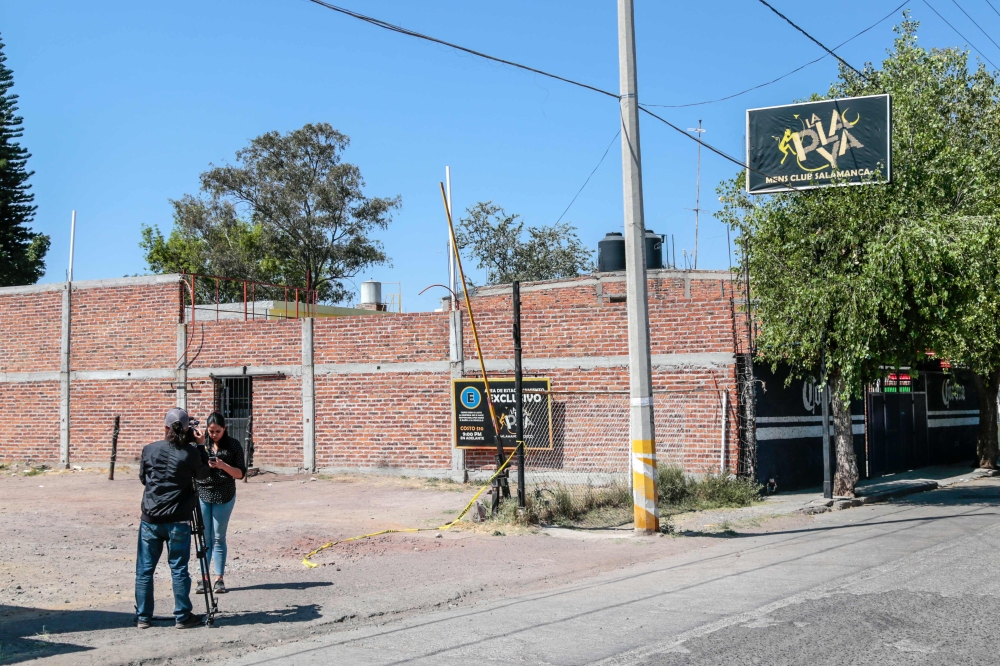 Journalists work outside the nightclub where at least 15 men were killed in an attack in Salamanca, Guanajuato state, Mexico, on March 9, 2019. AFP / STR