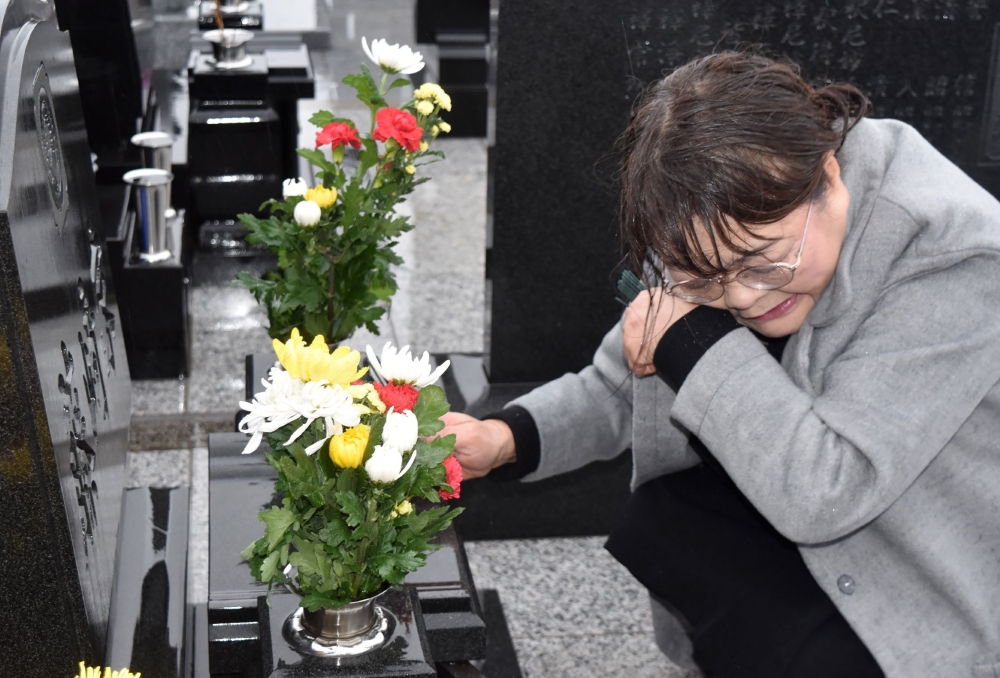 A woman pays her respects at a cemetery in Namie, Fukushima Prefecture on March 11, 2019 on the eighth anniversary of the 2011 tsunami disaster. Japan OUT / AFP / JIJI PRESS / JIJI PRESS
 
