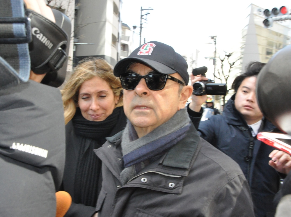 Former Nissan chairman Carlos Ghosn (C) is surrounded by the media as he goes out in Tokyo on March 9, 2019. Japan OUT / AFP / JIJI PRESS / JIJI PRESS