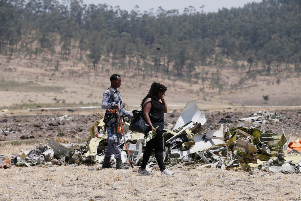 A Kenyan woman looks at debris of the Ethiopian Airlines Flight ET 302 plane crash after a commemoration ceremony at the scene of the crash, near the town of Bishoftu, southeast of Addis Ababa, Ethiopia March 13, 2019. REUTERS/Baz Ratner