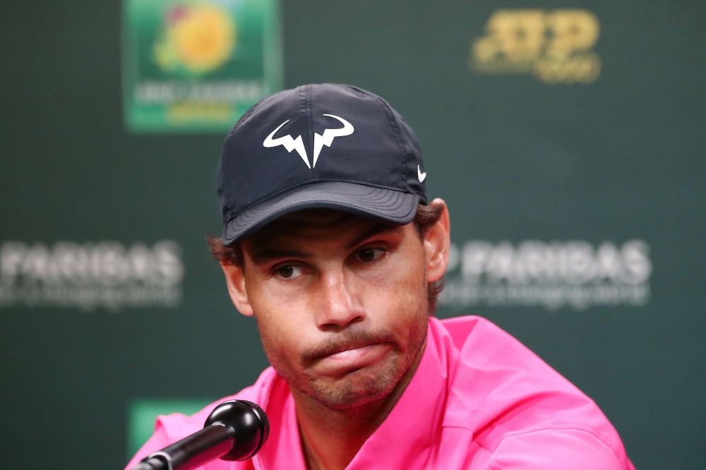 Rafael Nadal of Spain speaks to members of the media after withdrawing from his men's singles semifinal match against Roger Federer of Switzerland due to a right knee injury on Day 13 of the BNP Paribas Open at the Indian Wells Tennis Garden on March 16, 