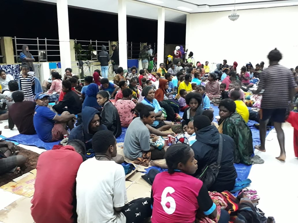 This handout picture taken and released by Indonesia's Badan Nasional Penanggulangan Bencana (BNPB), the accident mitigation agency, on March 17, 2019 shows local residents gather at a temporary shelter in Sentani, near the provincial capital of Jayapura,