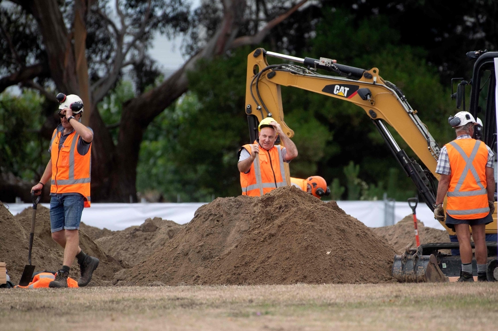 Workers dig grave sites at a cemetery in Christchurch on March 17, 2019 two days after a shooting incident at two mosques in the city. / AFP / Marty MELVILLE 