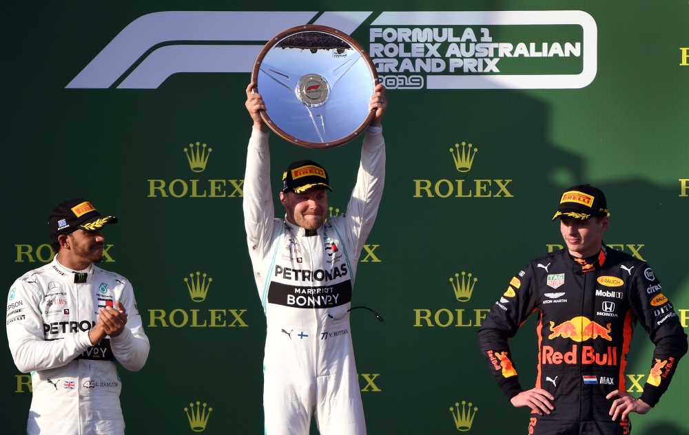 Mercedes' Finnish driver Valtteri Bottas (C) celebrates with the trophy next to second-placed Mercedes' British driver Lewis Hamilton (L) and third-placed Red Bull Racing's Dutch driver Max Verstappen (R) on the podium after the Formula One Australian Gra