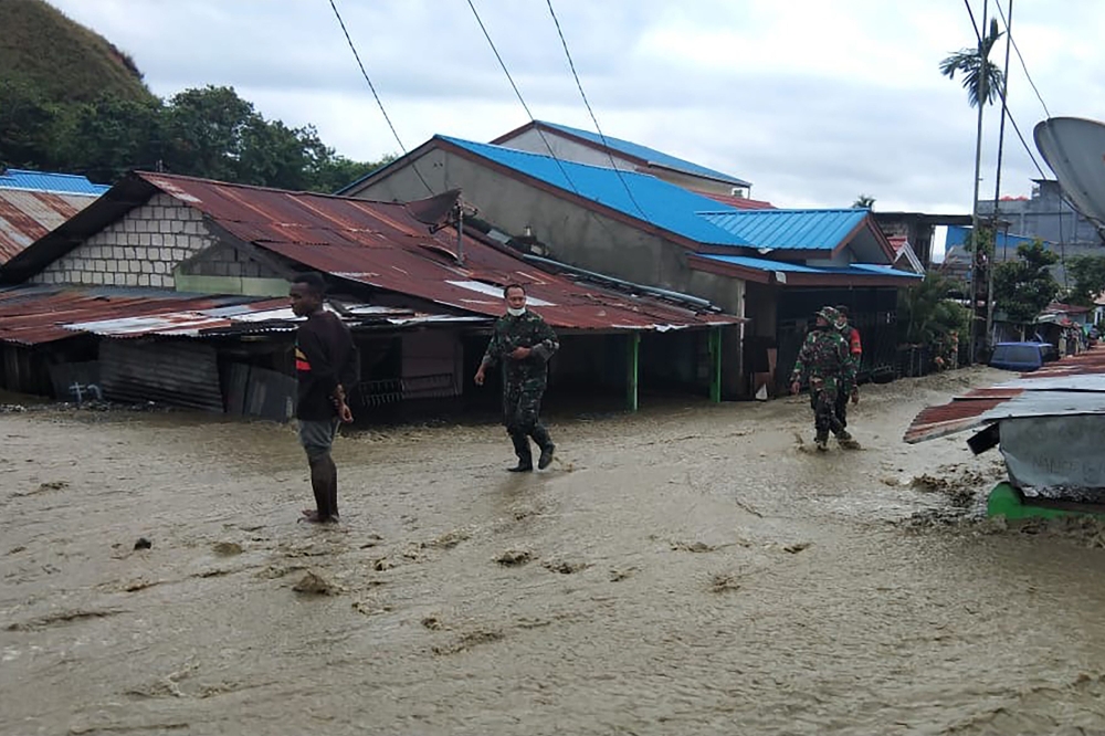 This handout picture taken and released by Indonesia Military on March 18, 2019 shows soldiers looking for survivors in a flooded area in Sentani. AFP PHOTO / INDONESIA MILITARY