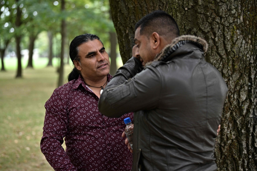 Afghan refugee and local resident Abdul Aziz (L), 48, speaks with a man who came to thank him for his bravery, during an interview with AFP in Christchurch on March 17, 2019, two days after he chased a gunman during a shooting incident at the Linwood Mosq