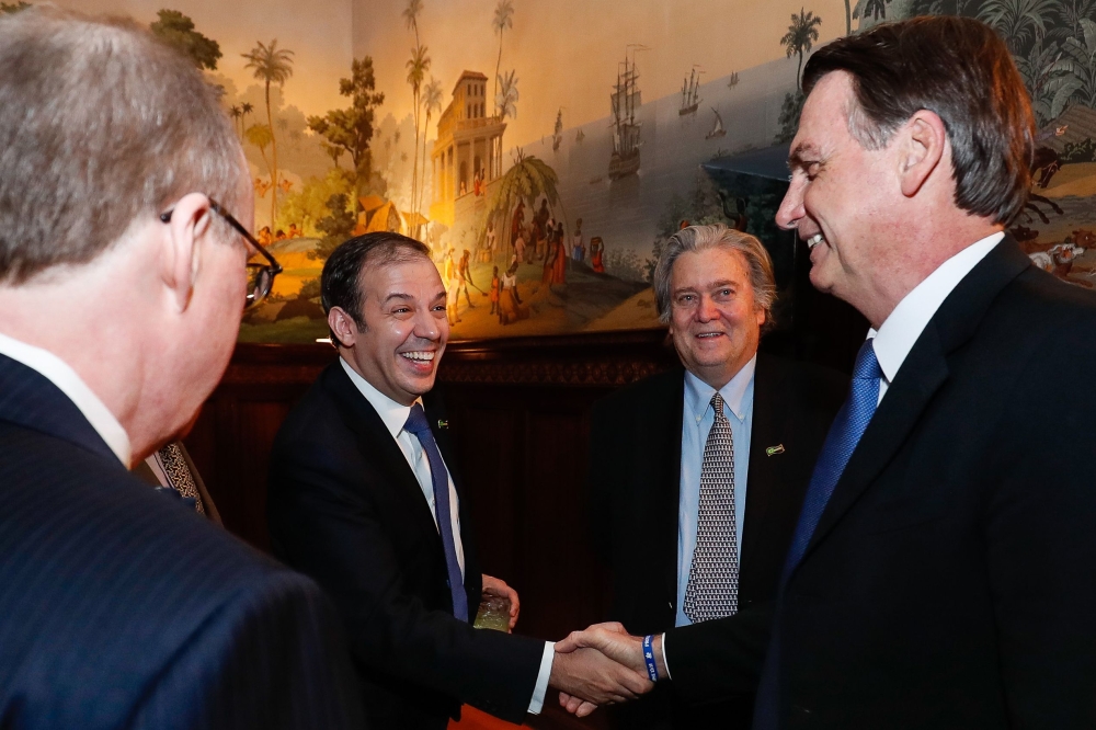 Brazilian President Jair Bolsonaro (R) greeting New Criterion Magazine Editor Roger Kimball (L), Investments Director of Pantera Capital Gerald Brant (2-L) and US President Donald Trump's former strategist Stephen Bannon (2-R) during a meeting with right-