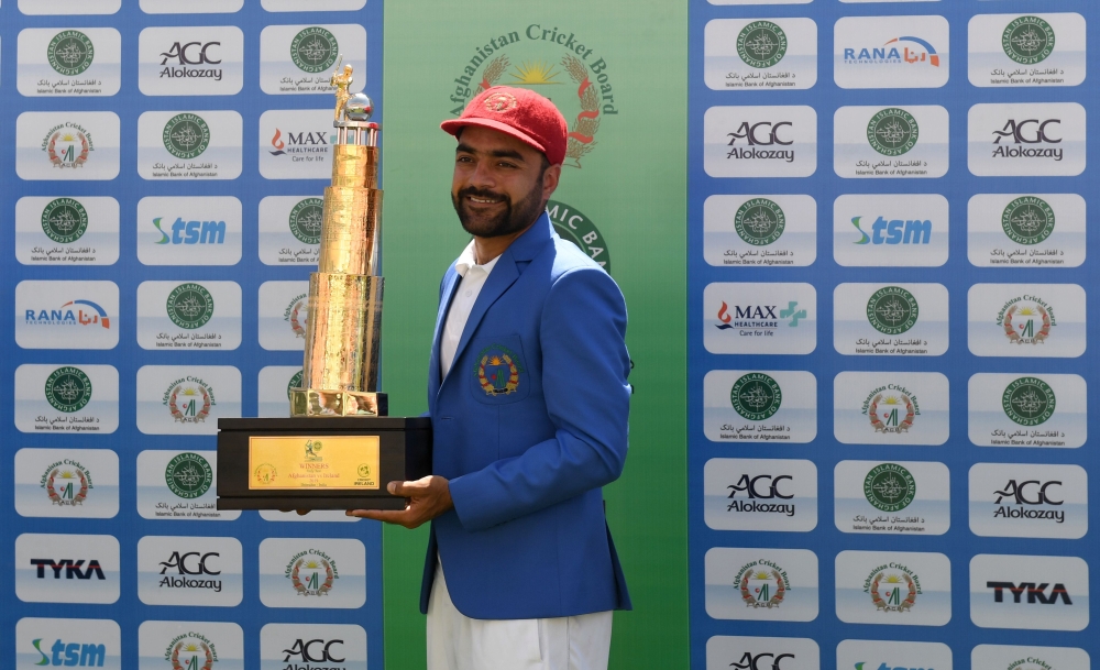 Afghanistan's Rashid Khan poses with the trophy after winning the Test cricket match between Afghanistan and Ireland at the Rajiv Gandhi International Cricket Stadium in the northern Indian city of Dehradun on March 18, 2019. AFP / Money Sharma 