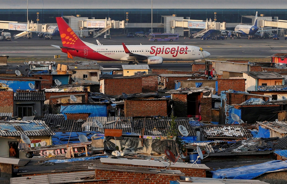 A SpiceJet passenger aircraft taxis on the runway at the airport next to a slum area in Mumbai December 19, 2014. Reuters/Shailesh Andrade