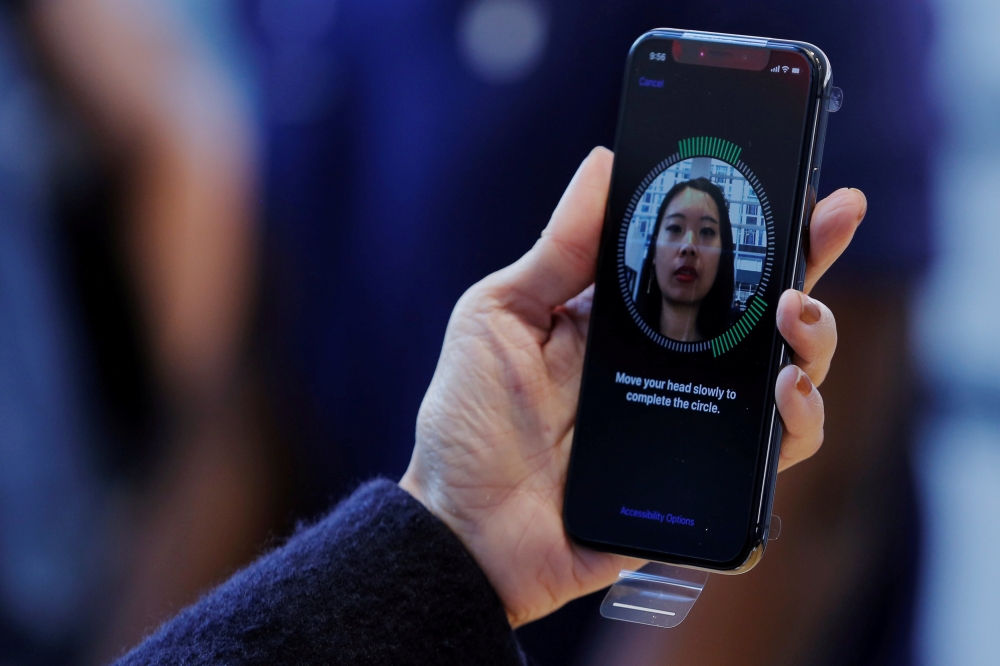 A woman sets up her facial recognition as she looks at her Apple iPhone X at an Apple store in New York, November 3, 2017. Reuters/Lucas Jackson