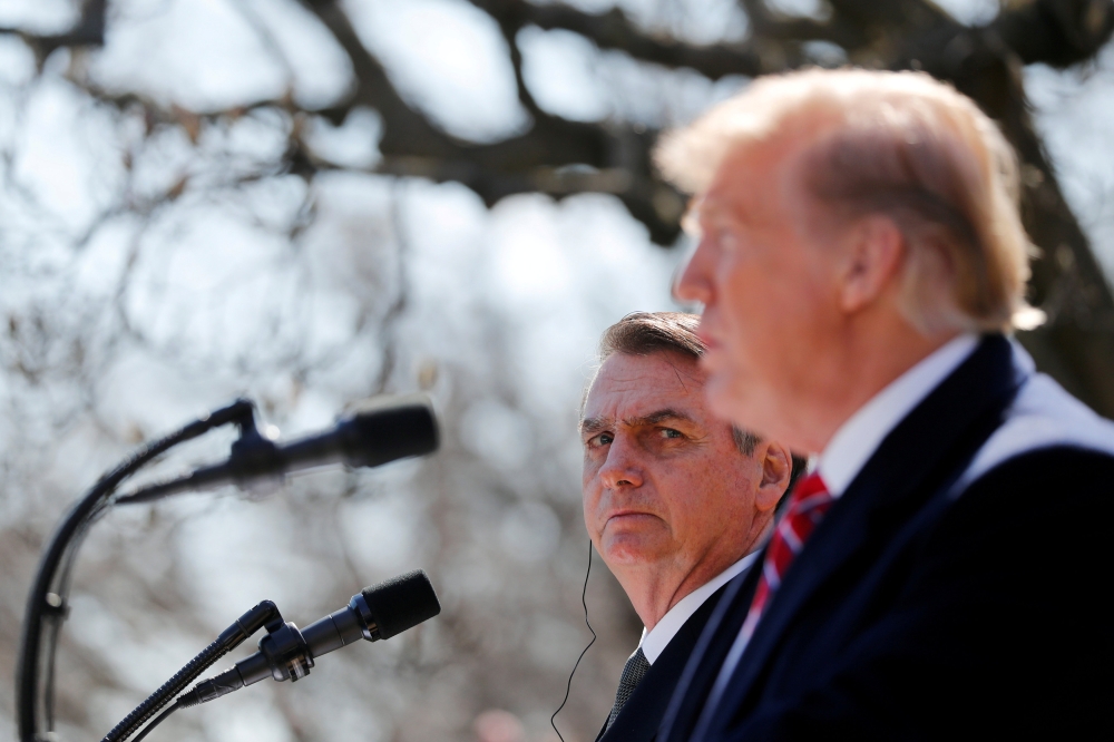Brazilian President Jair Bolsonaro listens to US President Donald Trump during a joint news conference in the Rose Garden of the White House, March 19, 2019. Reuters/Carlos Barria  
