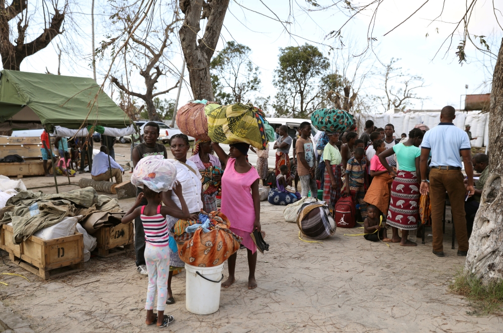 Evacuees from Buzi village carry their belongings as they arrive at the displacement center near the airport, after Cyclone Idai, in Beira, Mozambique, March 25, 2019. REUTERS/Siphiwe Sibeko