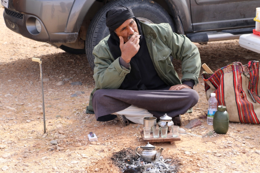 Milad Mohamad, a Truffle hunter, smokes a cigarette at a camp site during a search for white truffles, known locally as 