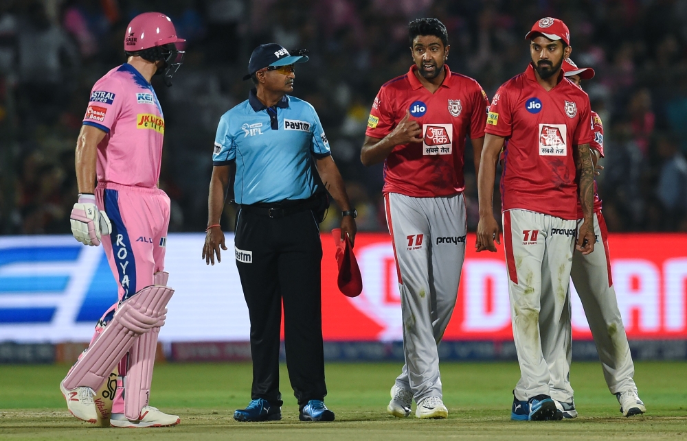 Rajasthan Royals' Jos Buttler (L) exchanges words with Kings XI Punjab's Ravichandran Ashwin (2ndR) during the 2019 Indian Premier League (IPL) Twenty20 cricket match between Rajasthan Royals and Kings XI Punjab at the Sawai Mansingh stadium in Jaipur on 