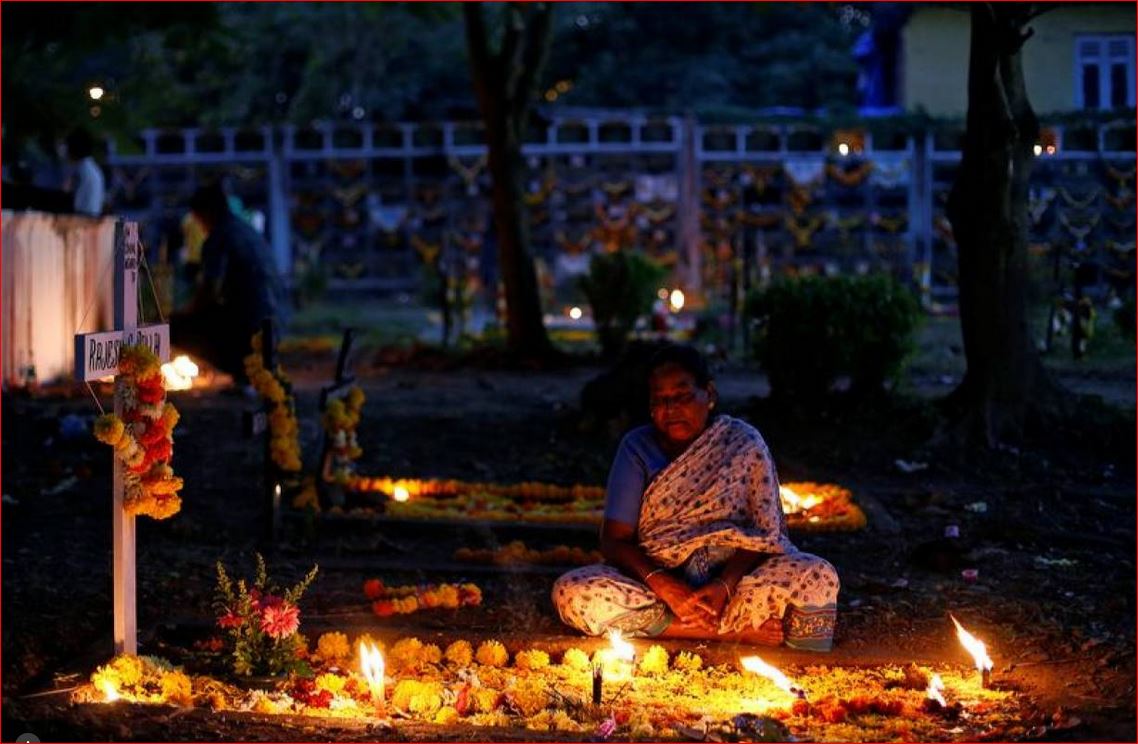 Archive Photo: A woman prays beside the grave of her relative at a cemetery during the observance of All Souls Day in Mumbai, India November 2, 2016. Reuters/Danish Siddiqui
