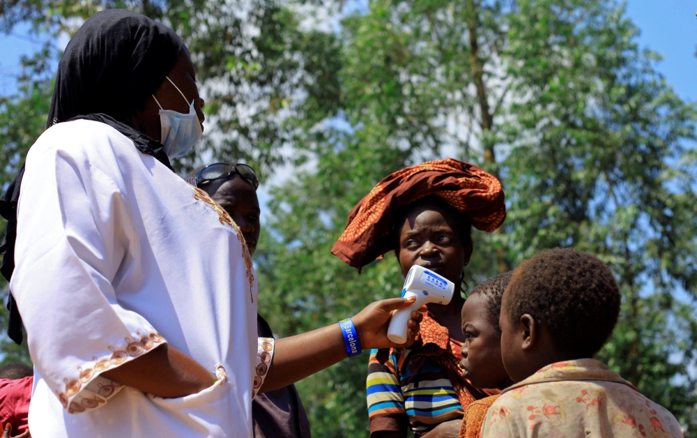 A Congolese health worker checks the temperature of a child before vaccination against the deadly Ebola virus near Mangina village, DR Congo, August 8, 2018. Reuters/Samuel Mambo