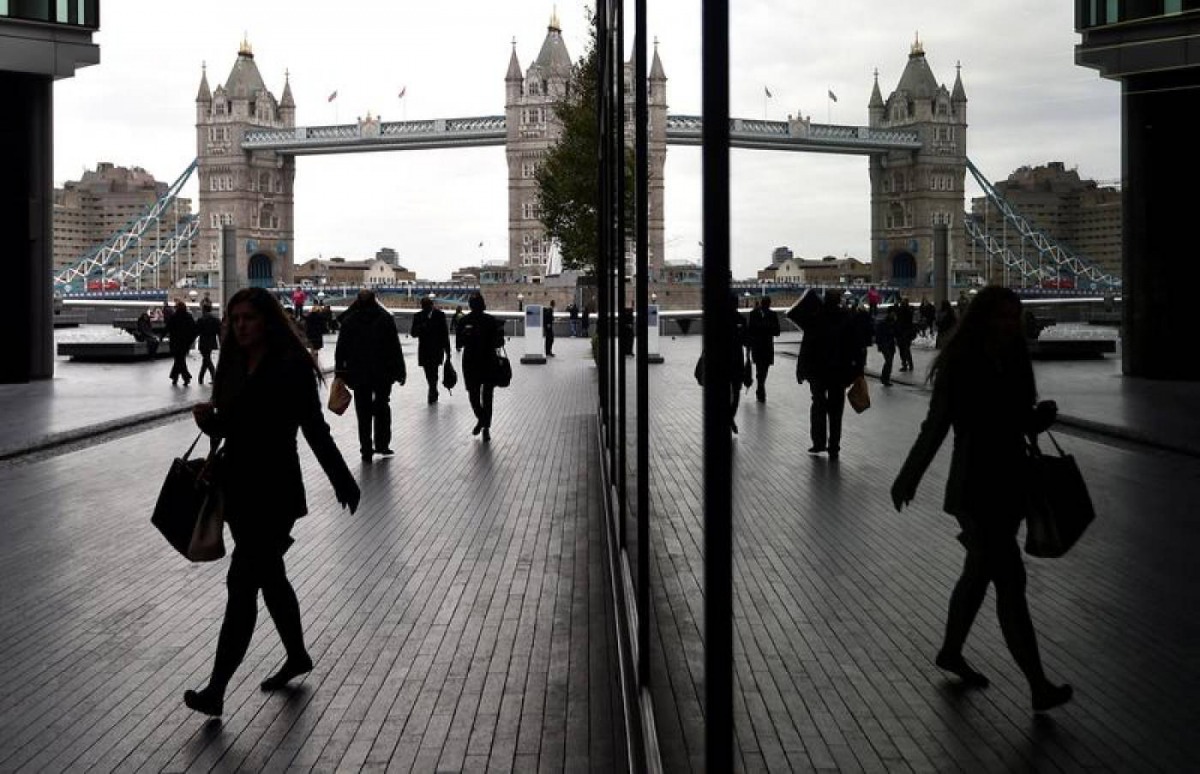 People walk through the More London business district with Tower Bridge seen behind in London, Britain, November 11, 2015. Reuters/Toby Melville