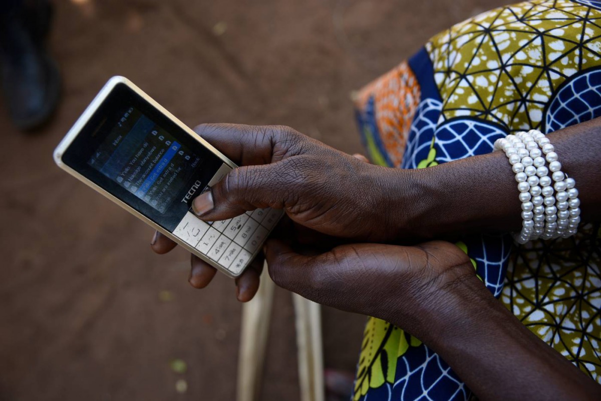Esther Nakisige, a beneficiary of the MUIIS farmer information service, checks her phone at her home in Iganga District, Uganda, on February 14, 2019. Thomson Reuters Foundation