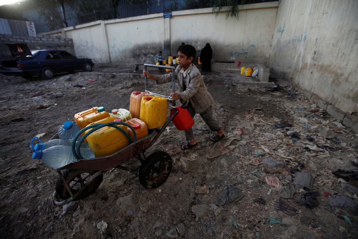 A boy pushes a wheelbarrow filled with water containers after collecting drinking water from a charity tap amid a cholera outbreak in Sanaa, Yemen, October 13, 2017. Reuters/Mohamed al-Sayaghi