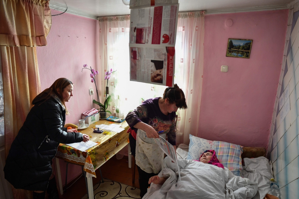 REPRESENTATIVE IMAGE: An immobilised elderly woman is helped to vote by a relative in a mobile ballot box in Bardar village on February 24, 2019 as Moldovans are to elect new parliament members. (AFP/Daniel Mihailescu) 